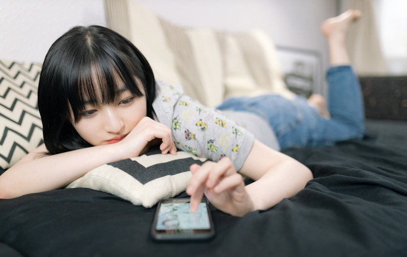 女性スマホをイジっている